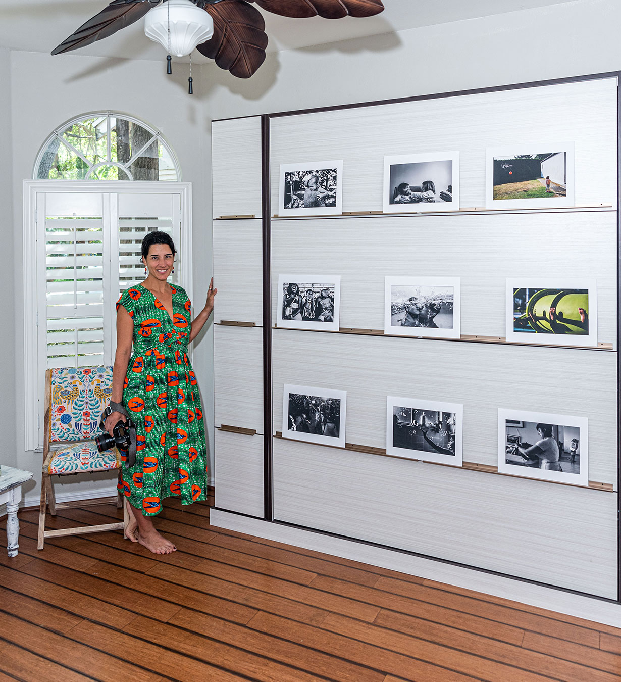 Aguenda stands by her new wall bed with the front displaying photos